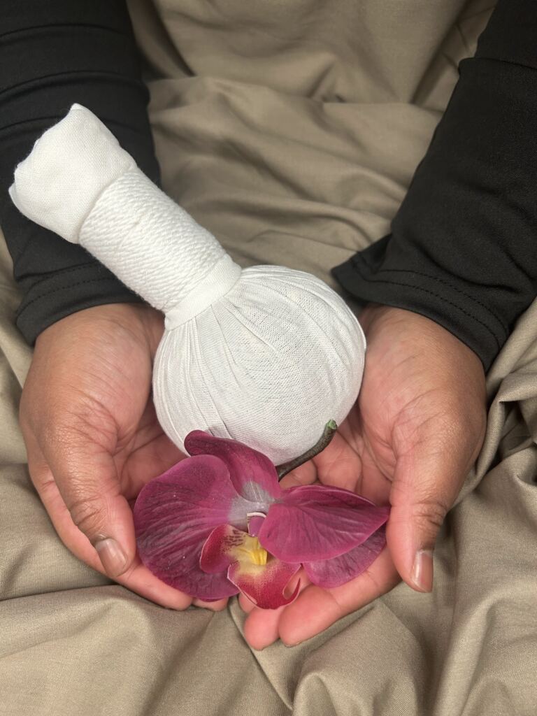 Pochon d’herbes et orchidée entre les mains de la praticienne